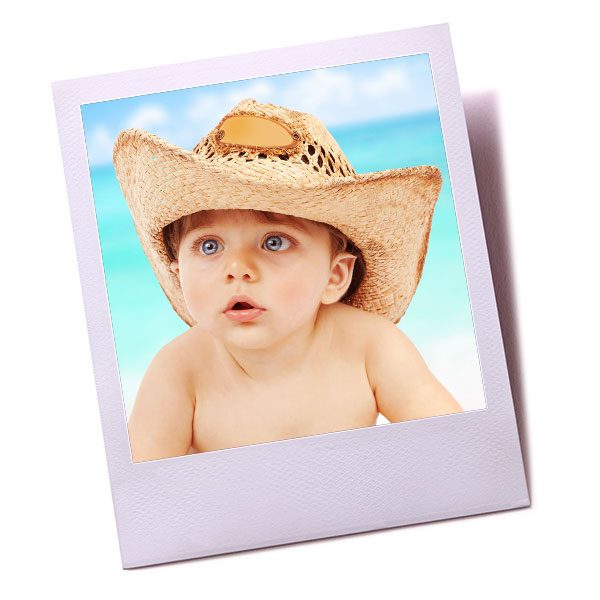 Baby on the beach wearing a straw hat
